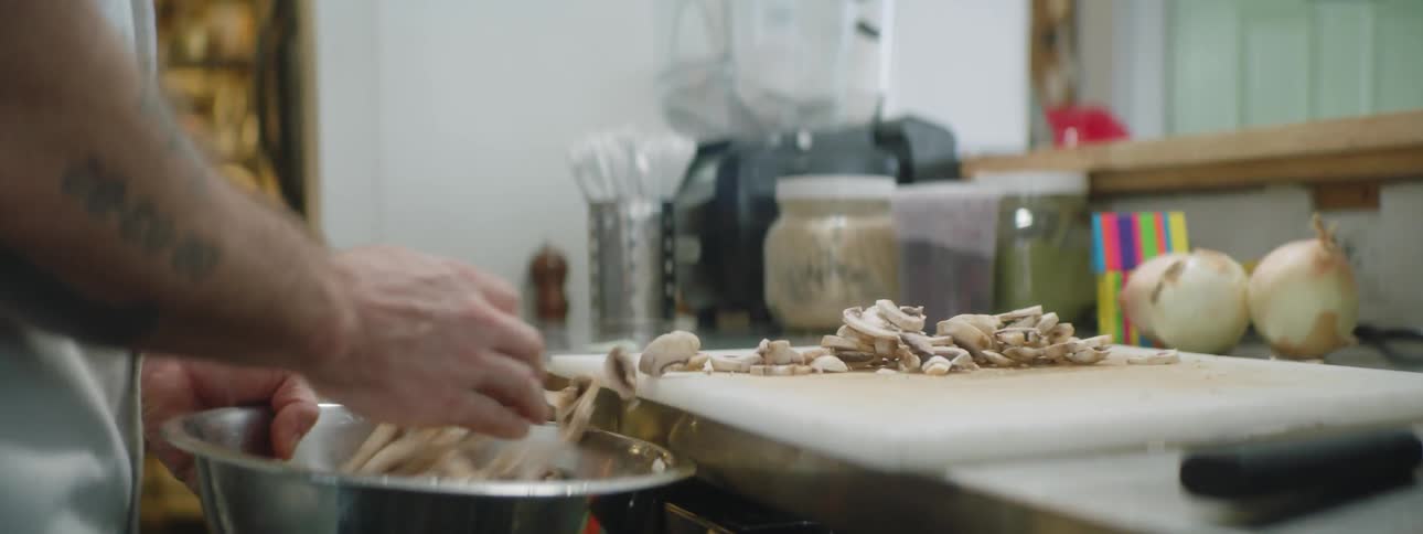 Man places mushrooms into bowl