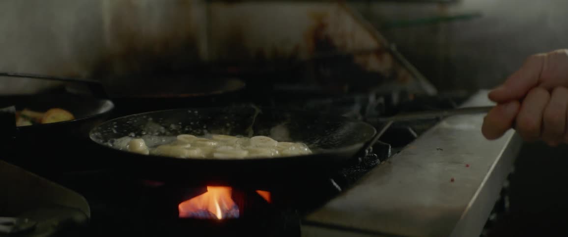 A man cooks bananas in a skillet