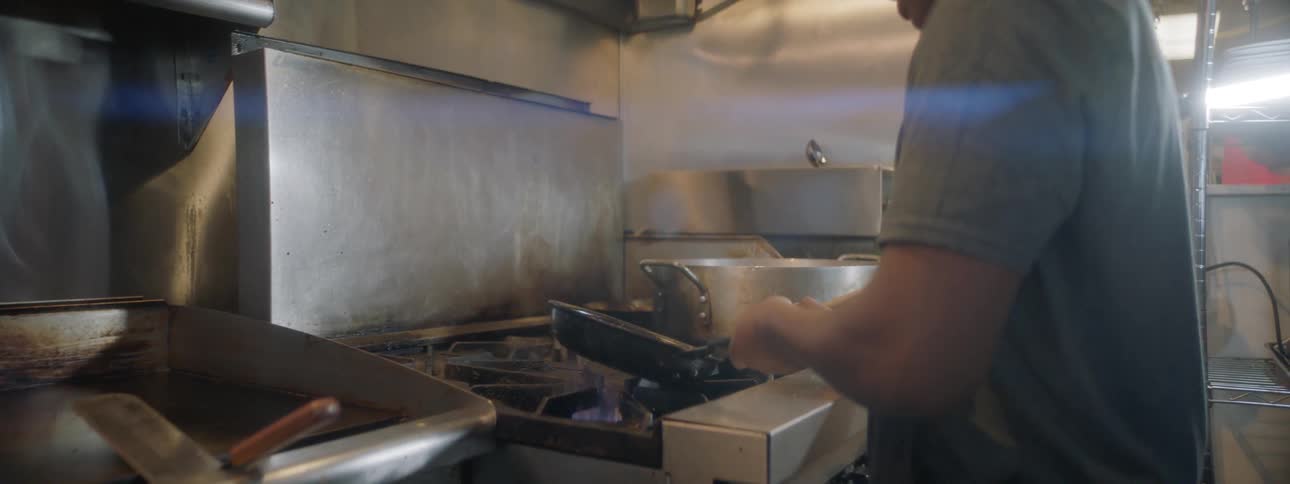 A young black man cooks an omelette