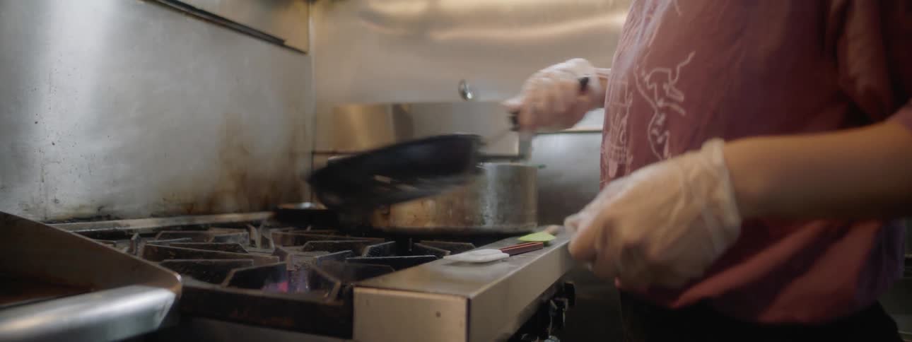 A woman frying eggs in a frying pan