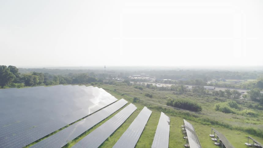 A field of solar panels is located near an interstate