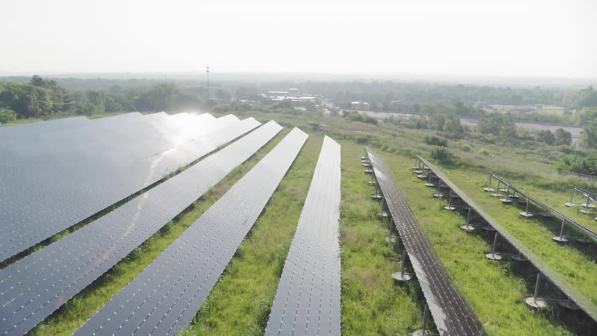 Rows of solar panels across a grassy hill
