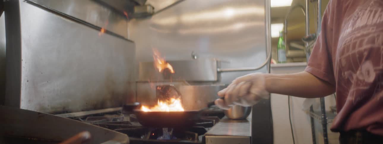 Woman cooks on industrial stove
