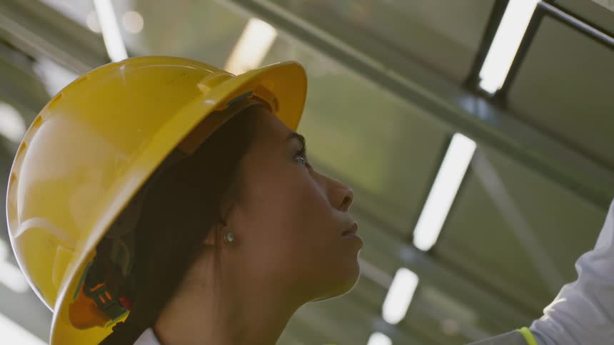 A woman inspecting a solar panel