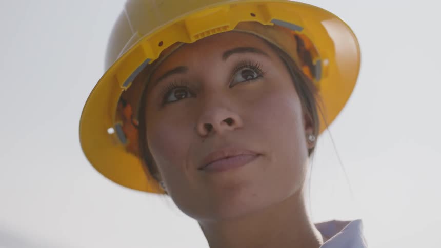 A woman with a hard hat looking into the sky
