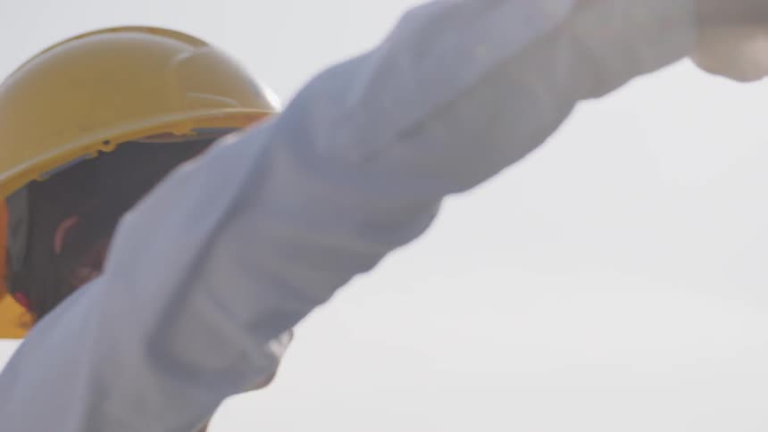 A woman in a hard hat opens a door