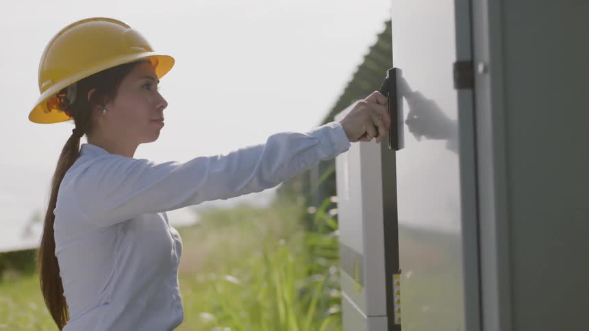 A young woman in a hard hat opens a door