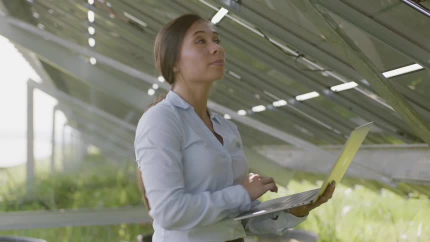 A woman looks to a computer then around at her surroundings