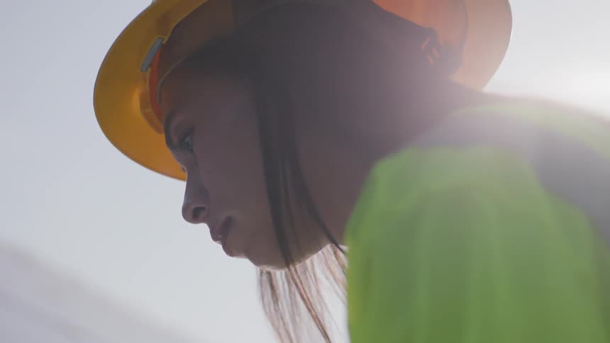 Woman in hard hat examining something