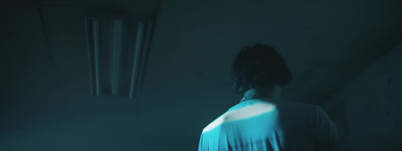 A young boy walks in a room with a strobe light