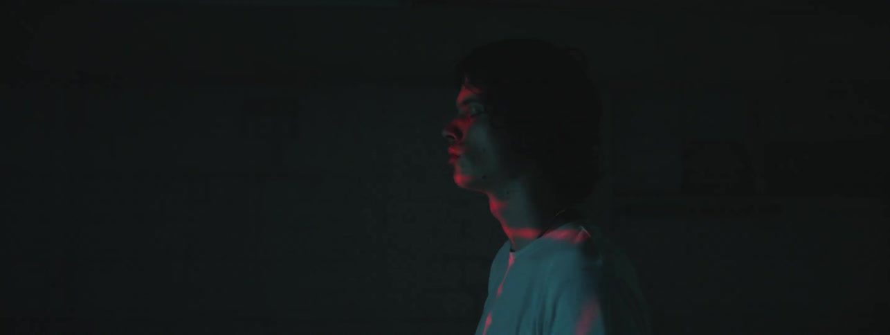A man standing in a dark room with flashing strobe lights
