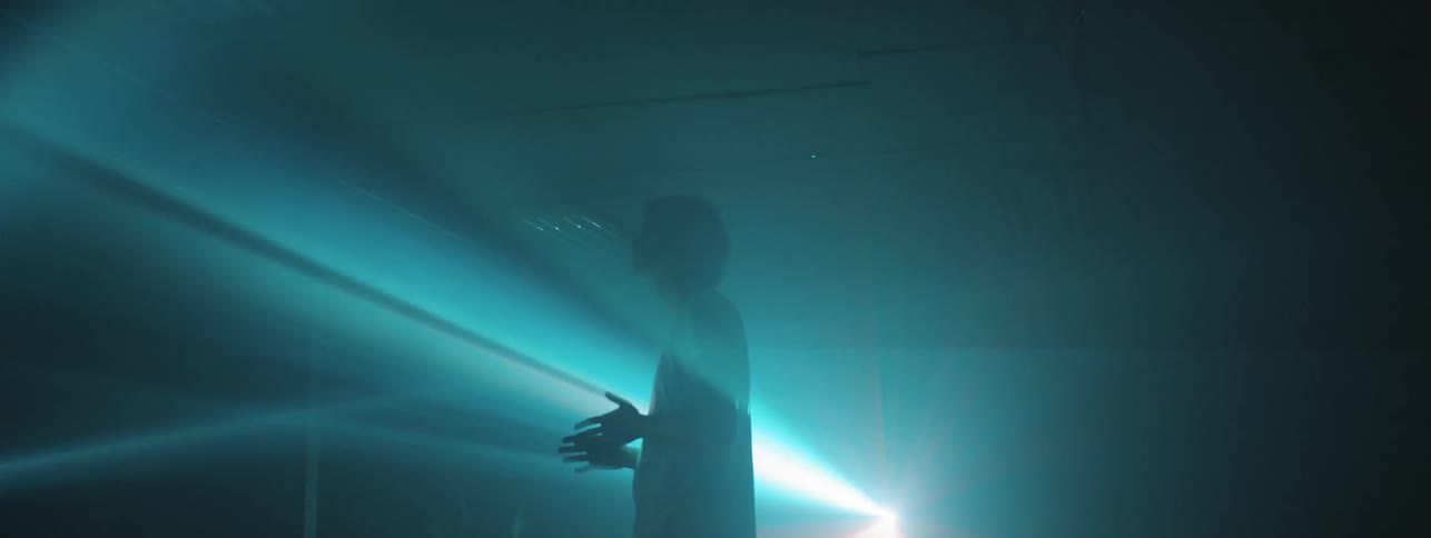 A man standing in the middle of a light show
