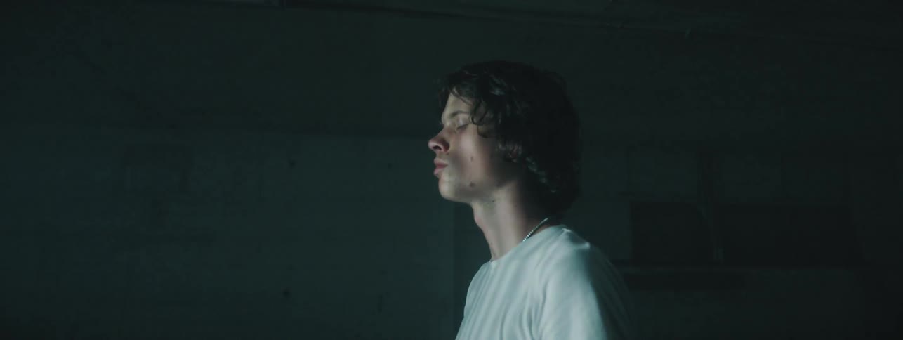 Man standing with eyes closed in abandoned building with rapid shadow and light