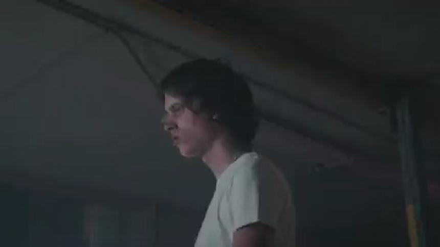 A man walks in a circle in room with strobe lights