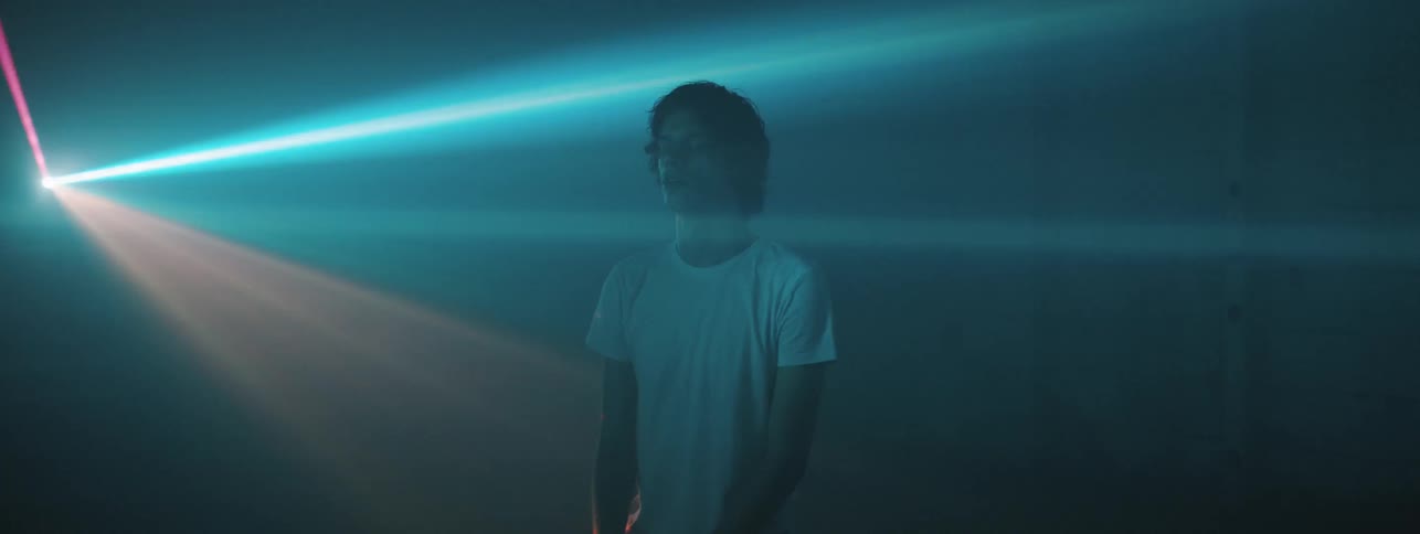 A man in the center of bright flashing strobe lights