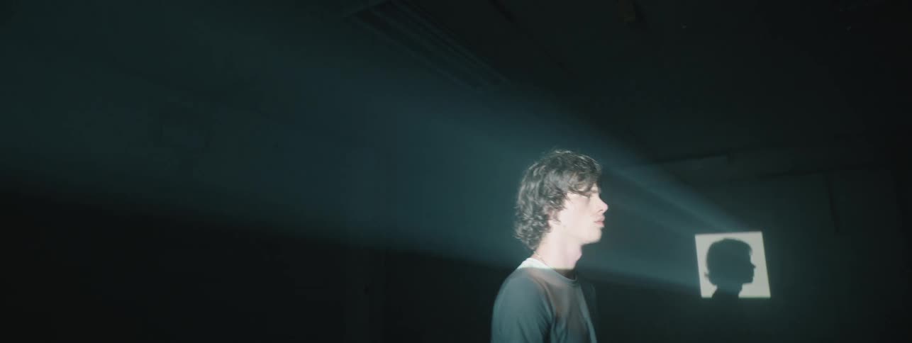 A projection light casts a shadow of a man
