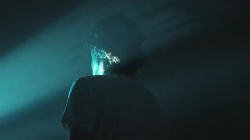 A man stands in a room with a strobe light