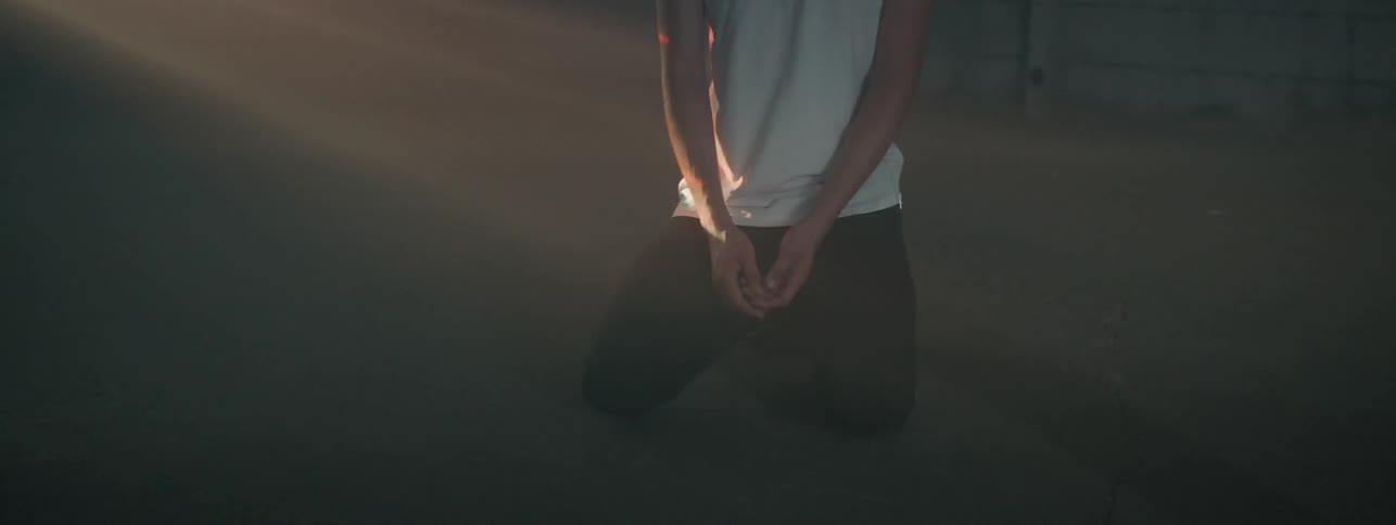A young man sits while lights flash around him