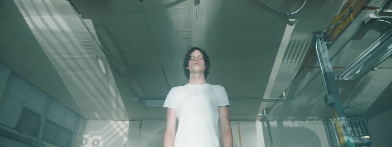 Man stands with eyes closed in front of strobing light patterns