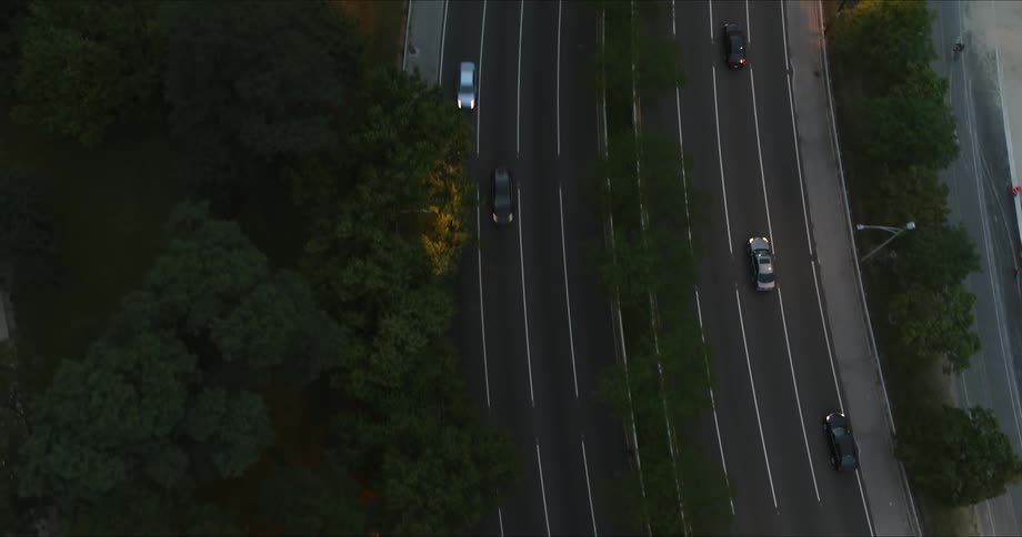 Vehicles drive on the divided highway at dusk