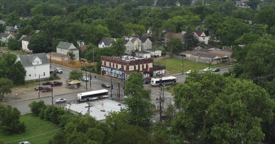 The vehicles travel through the intersection in town
