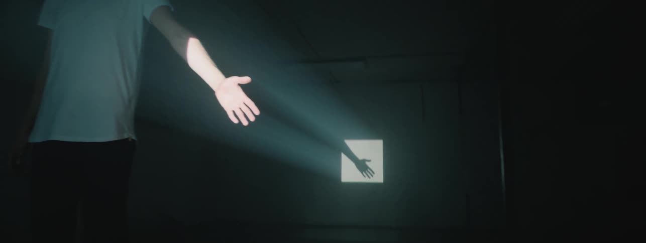 A man puts his hand in front of the projector light