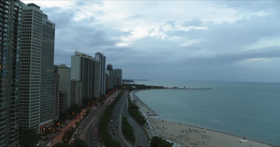 Cars drive on the highway opposite the city near the shore