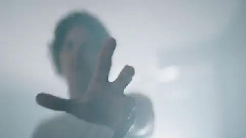A man is waving his hand under the strobe light