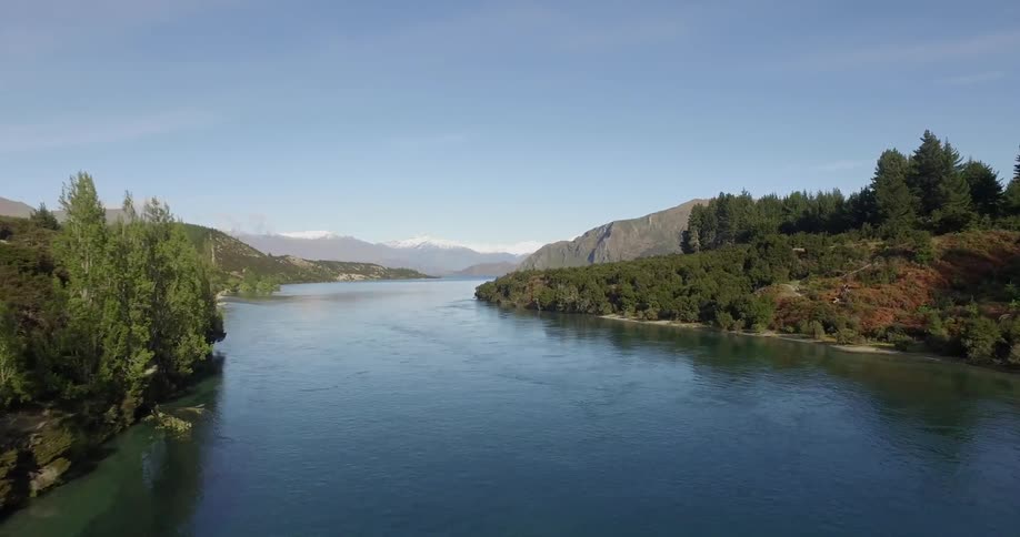 Passing by a riverbed leading to some mountains in the distance