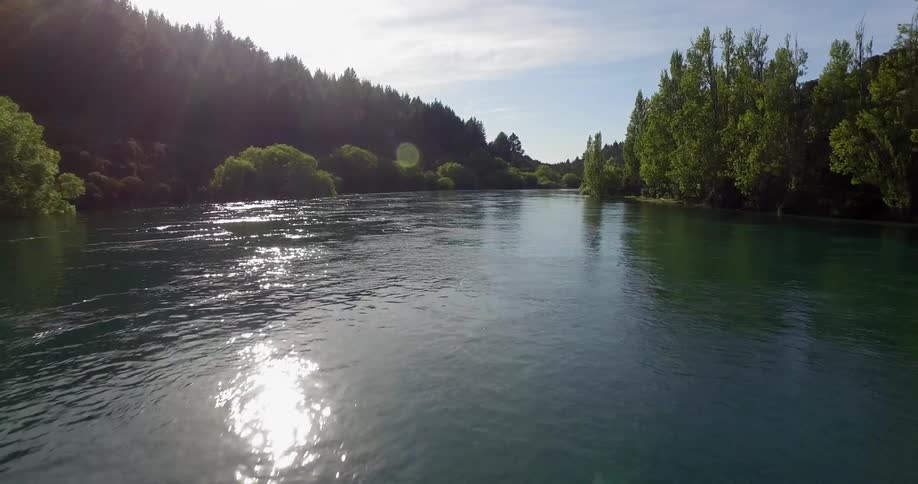 Water flows calmly along a tree lined river