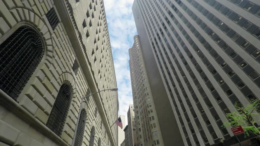 Drive down a road while looking up the buildings in a city