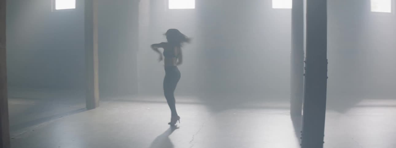 A woman pirouettes and falls to the floor in a dance studio