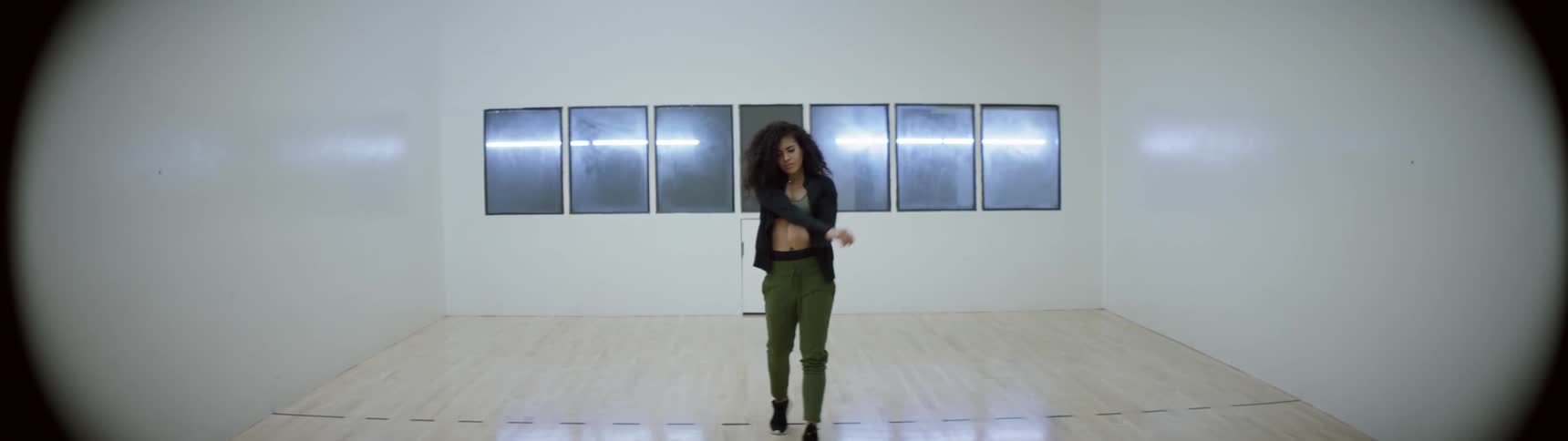 A black woman walks through a dance studio