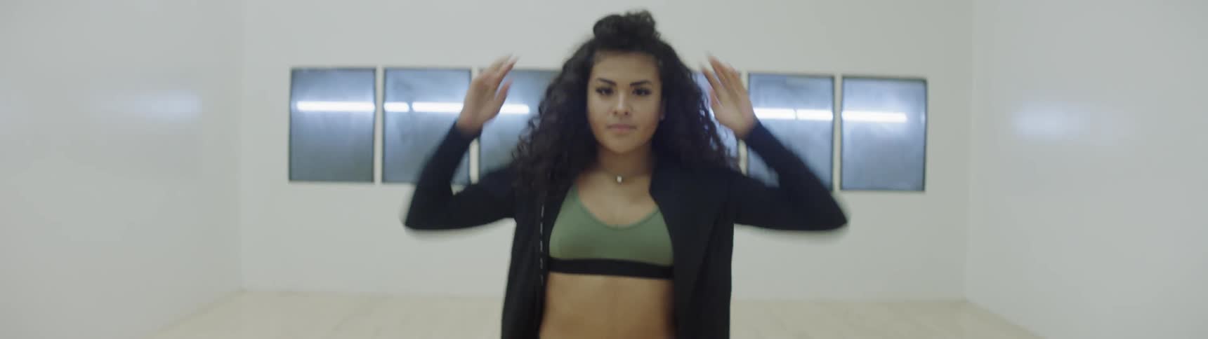 A woman puts her hair into a bun