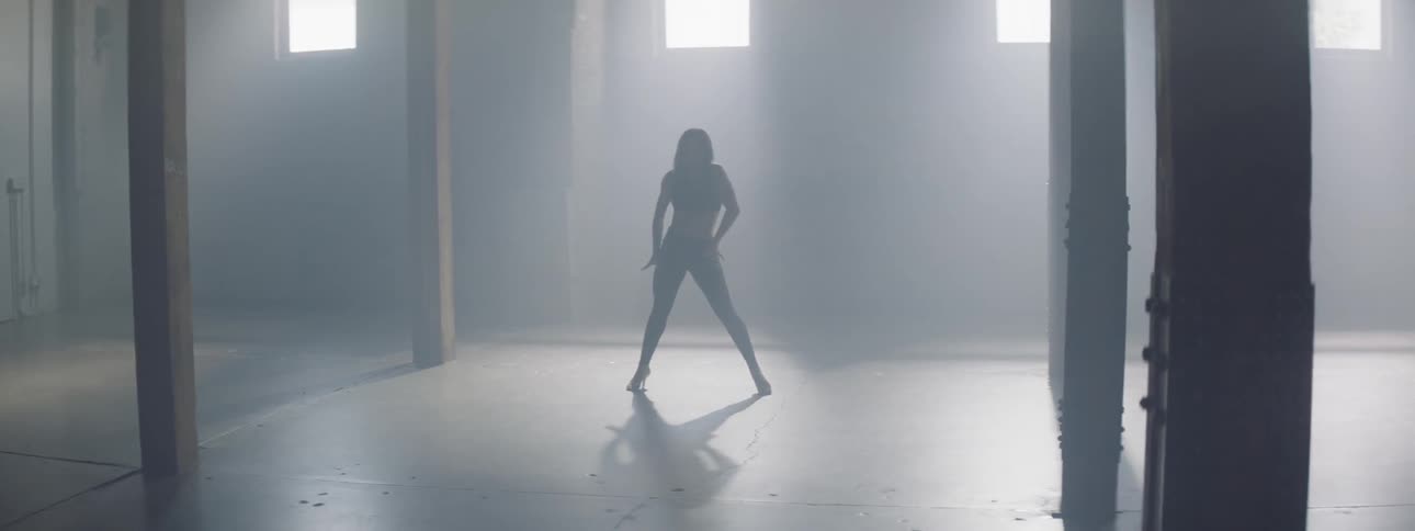 A woman dances down the hall