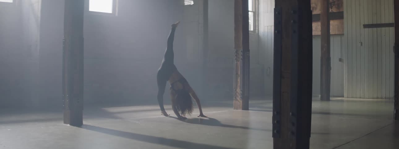 A woman is dancing in the dark hall