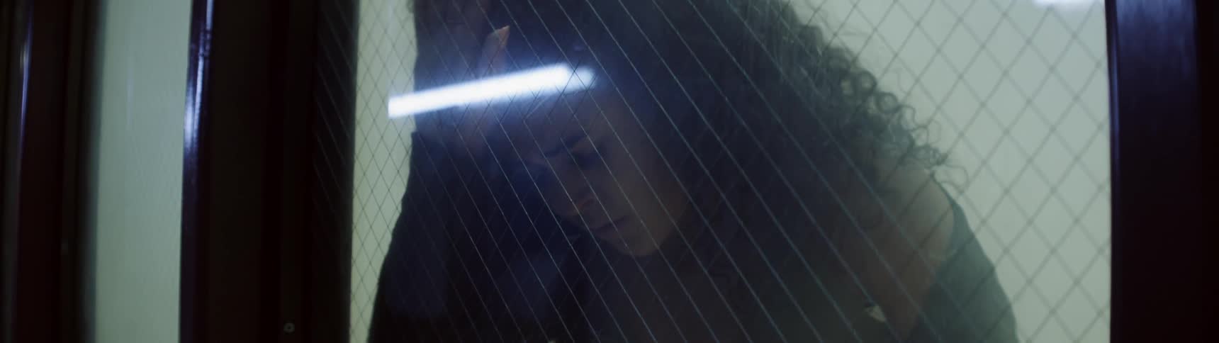 A woman is looking sad and by a glass door