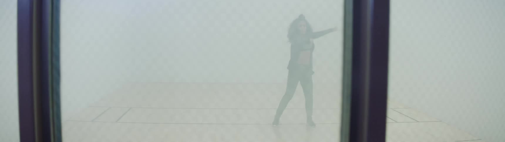 A woman dances in a well lit room