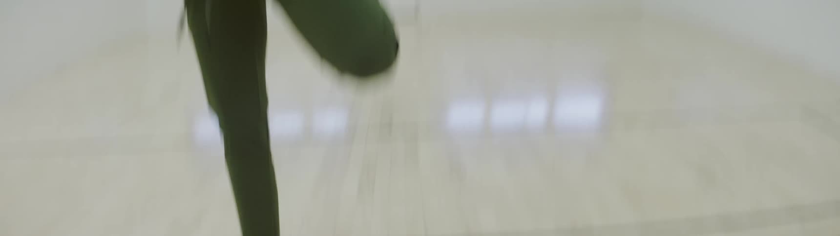 Young woman stretches legs on indoor basketball court