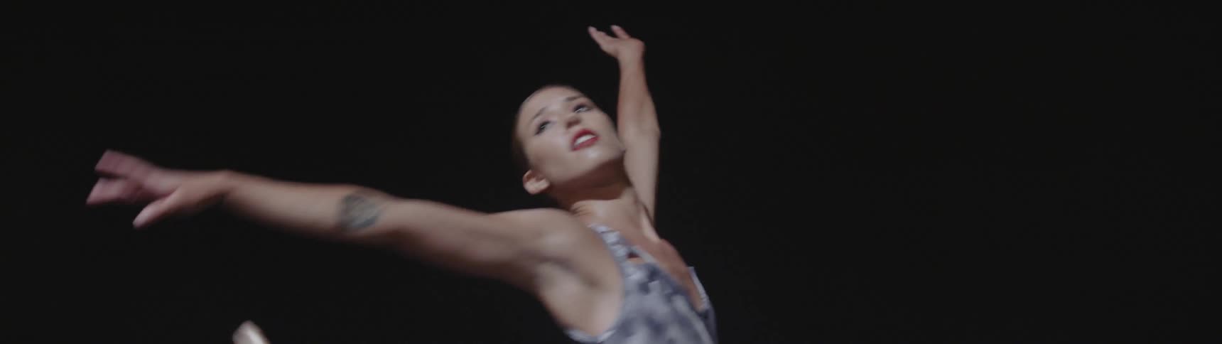 A young woman dances in a leotard
