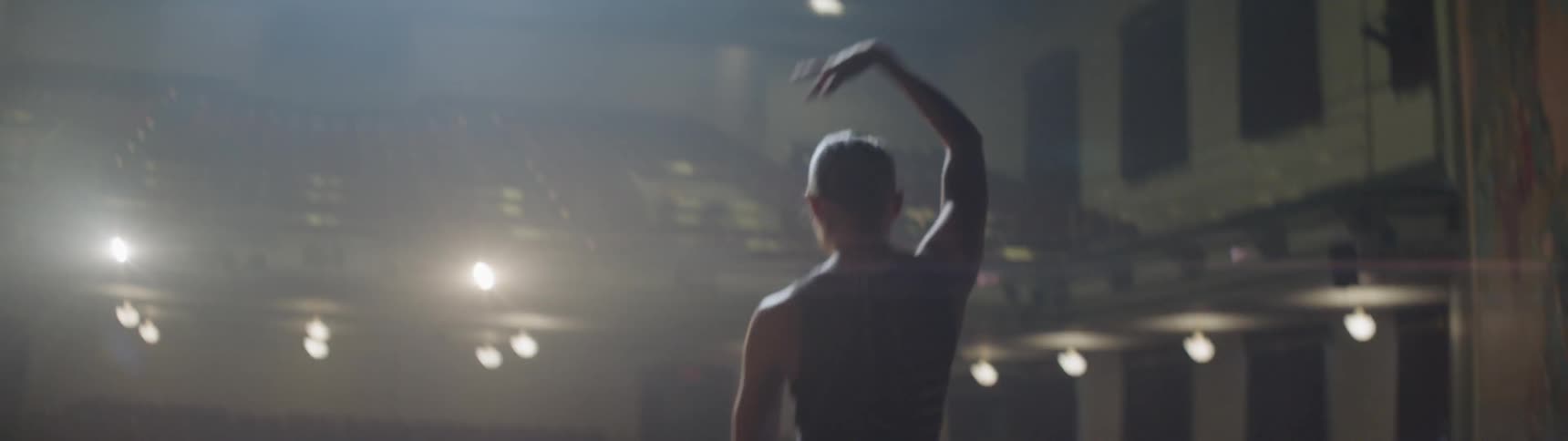 A woman dancing on a stage with bright lights