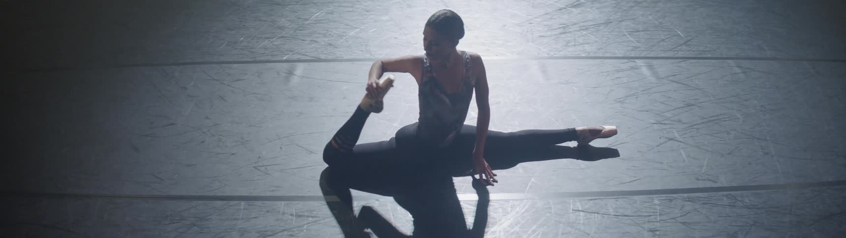 A dancer does the splits and stretches