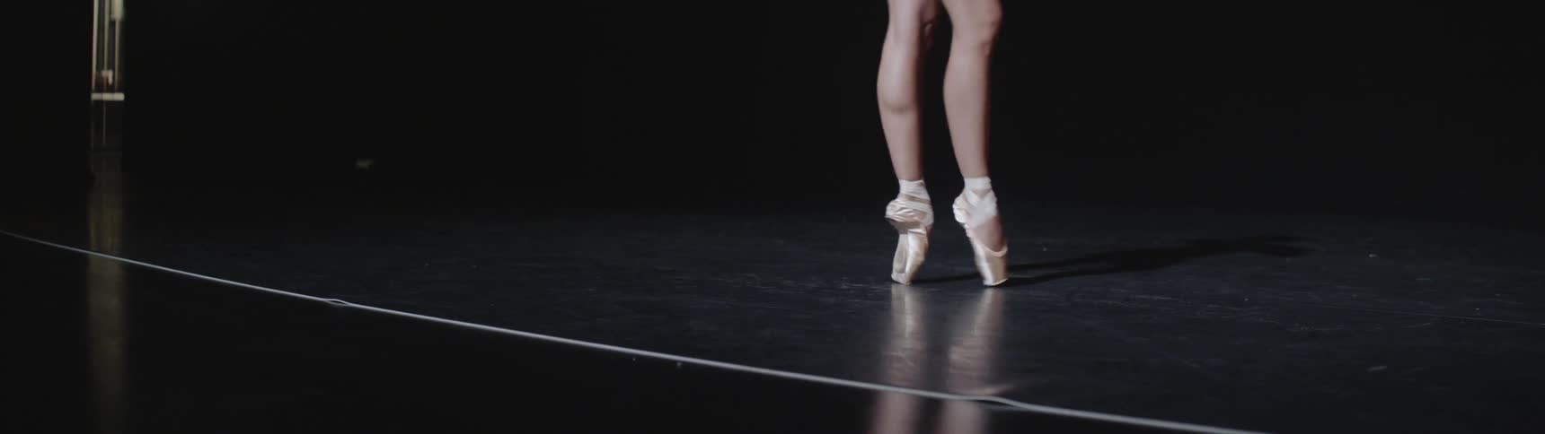 A ballerina twirls on her toes on a stage