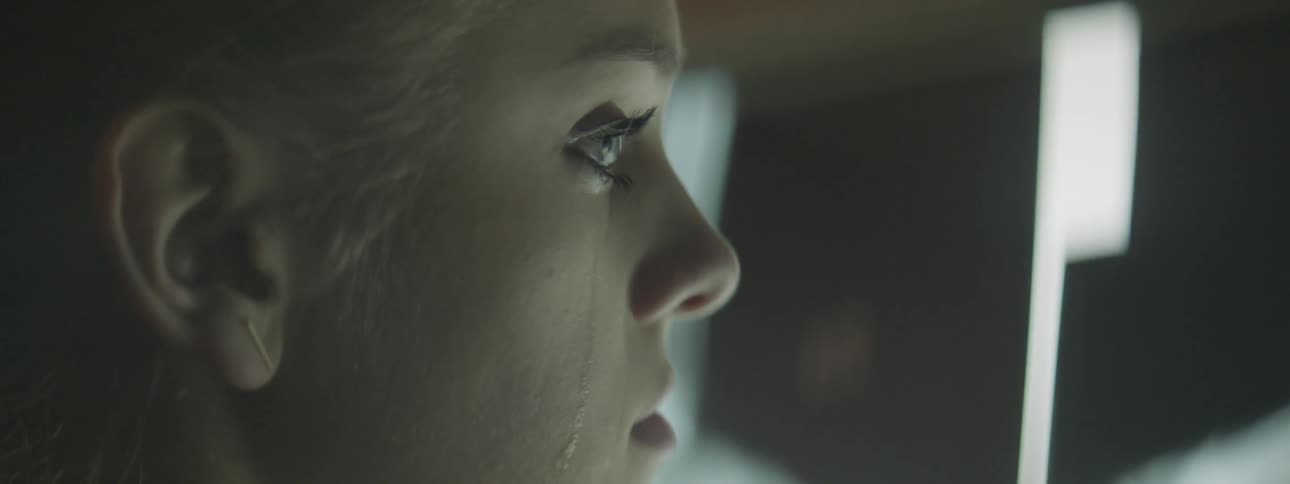 Blonde woman looks ahead and sheds tears at night