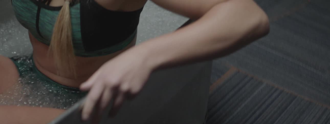 A woman is getting into a tub filled with ice