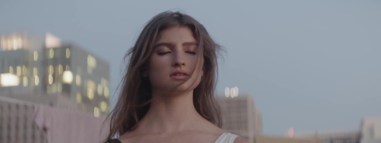 Woman meditating in the rooftop of a building at sunrise