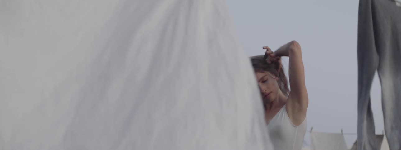 A young woman dances on a roof top