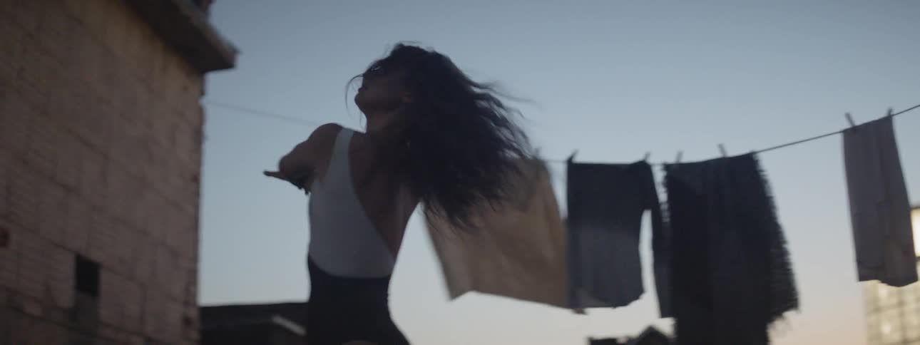 Dancer performing on the rooftop of a house