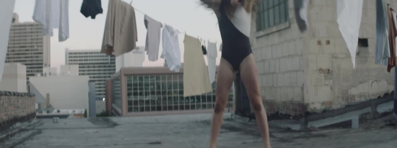 Dancer dance on roof among clothes lines
