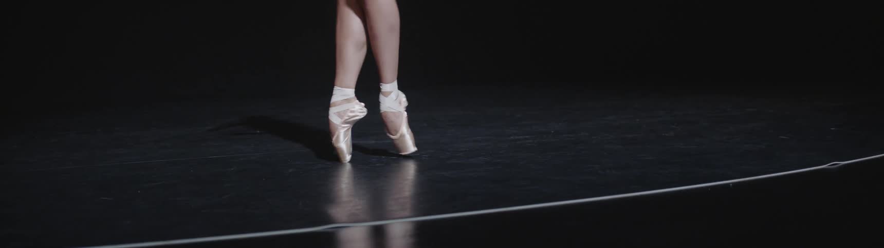 A ballerina dances on her toes